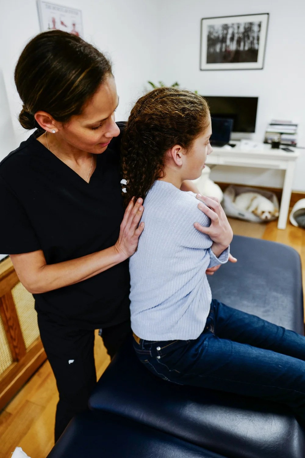 Osteopath performing gentle hands-on treatment on a young girl's back