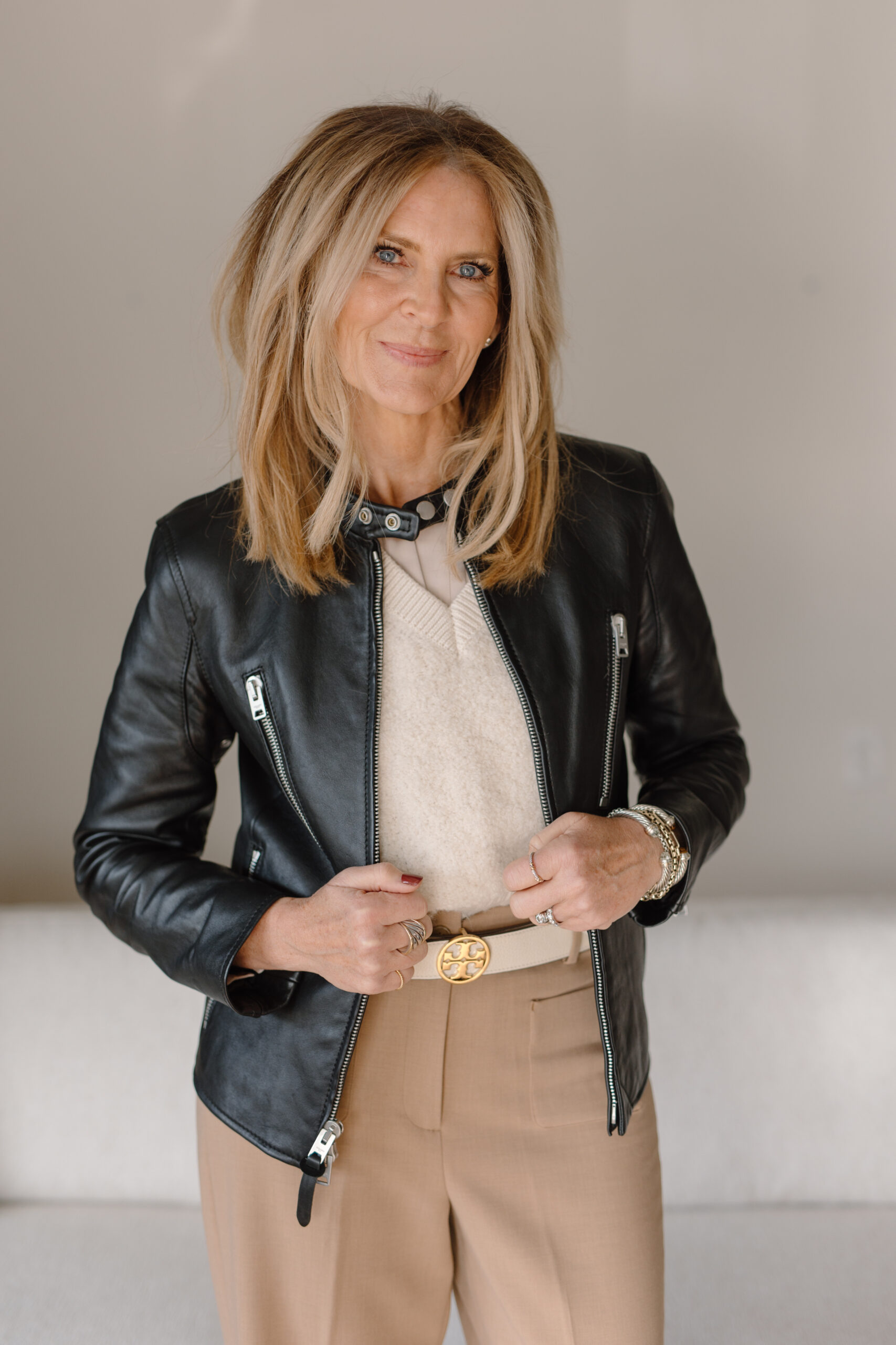 Laura Davidson, lead designer and owner of Dwellings, wearing a black leather jacket and professional attire.