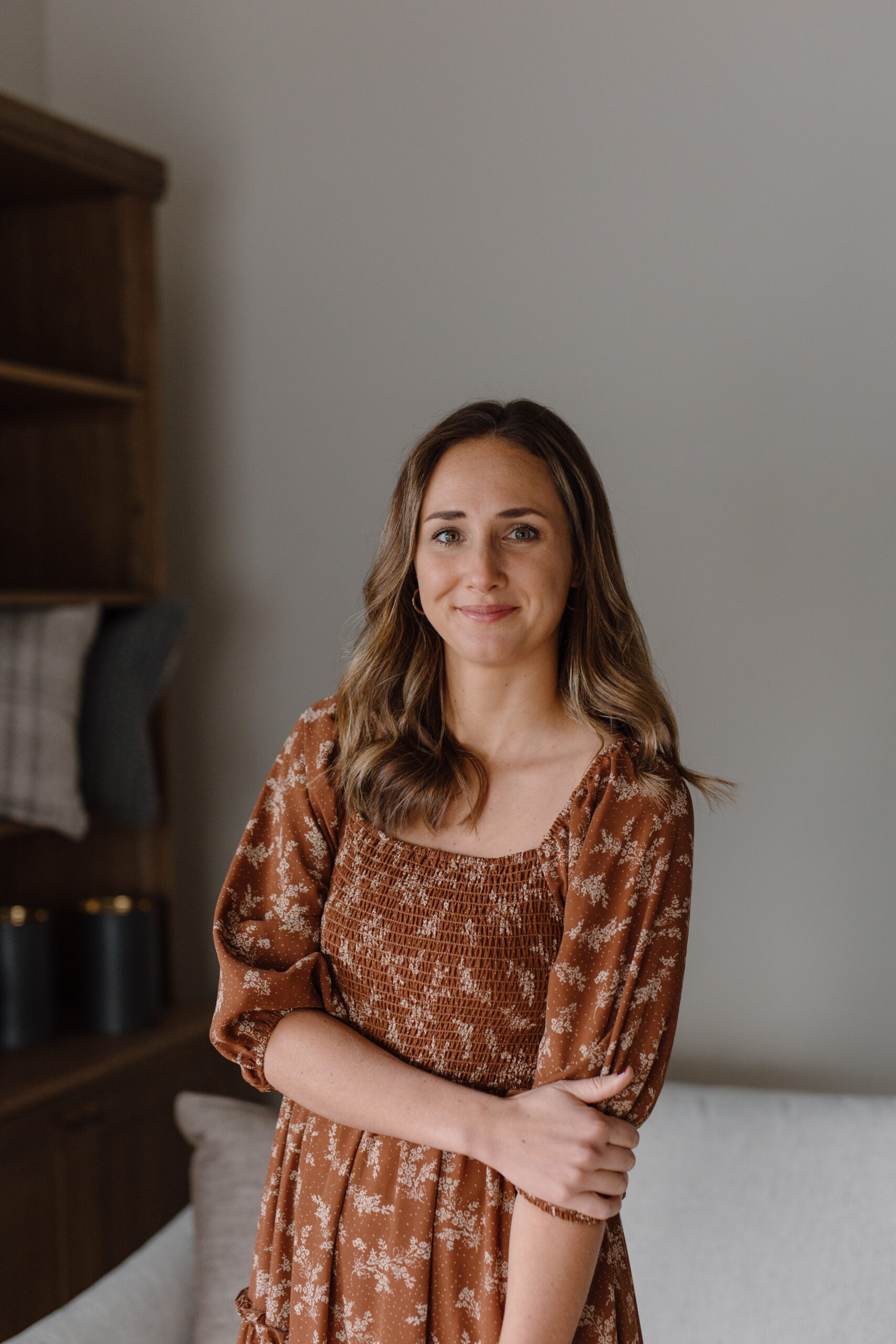 Lauren Wassink | Founder & Lead Designer at Lauren Wassink Interiors Lauren Wassink, lead designer and founder of Lauren Wassink Interiors, wearing a rust-colored floral smocked dress.