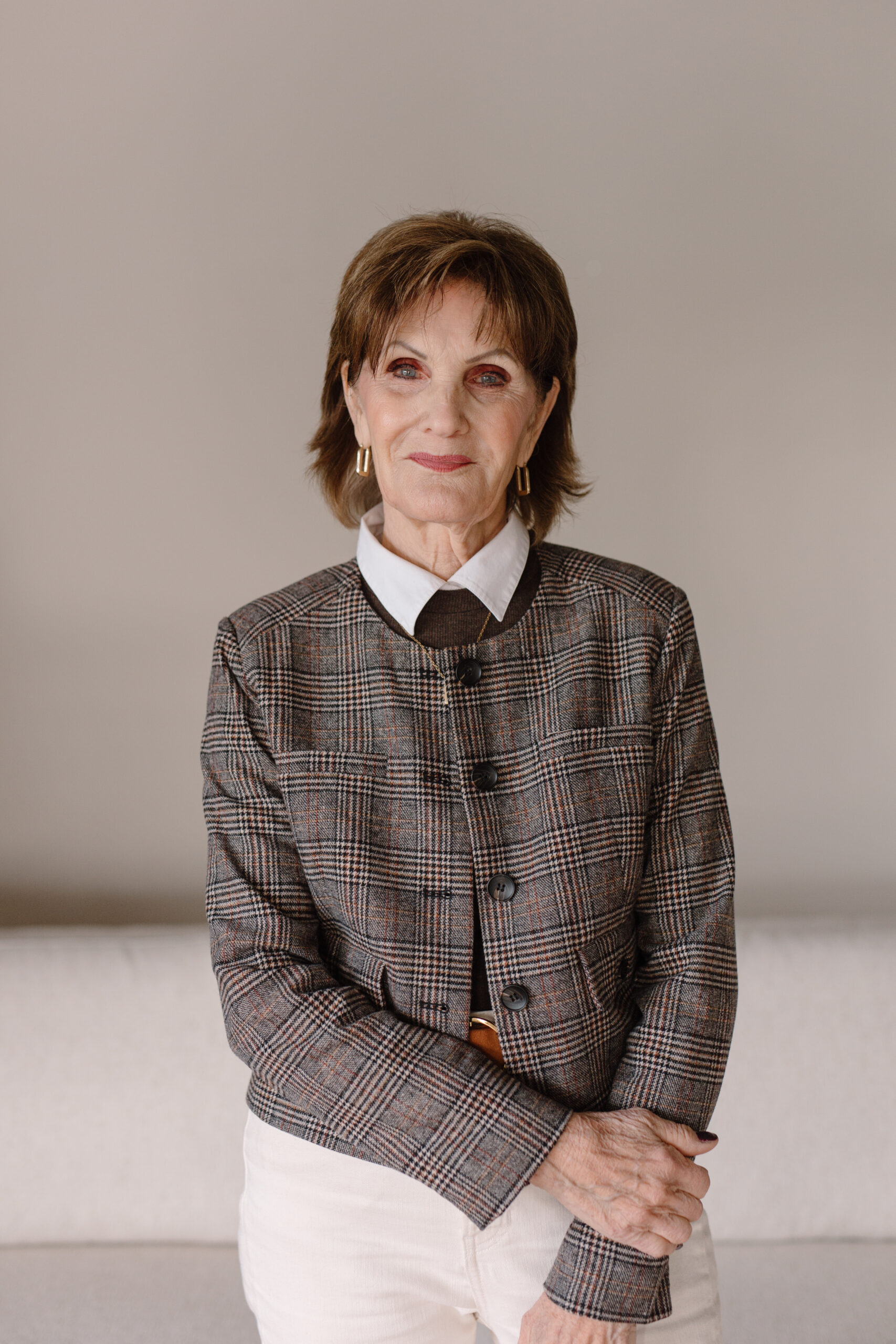 Linda Cambell | Studio Designer at Dwellings Linda Cambell, Studio Designer at Dwellings, wearing a plaid blazer and white collared shirt.